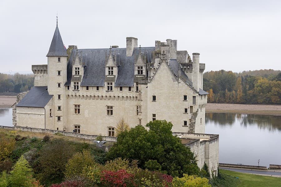 Le château de Montsoreau vu depuis la Loire, ses murs blancs plongeant dans le fleuve.